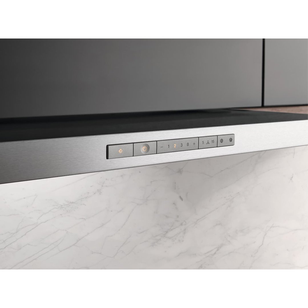 Close-up of a stainless steel rangehood with illuminated controls above a marble countertop