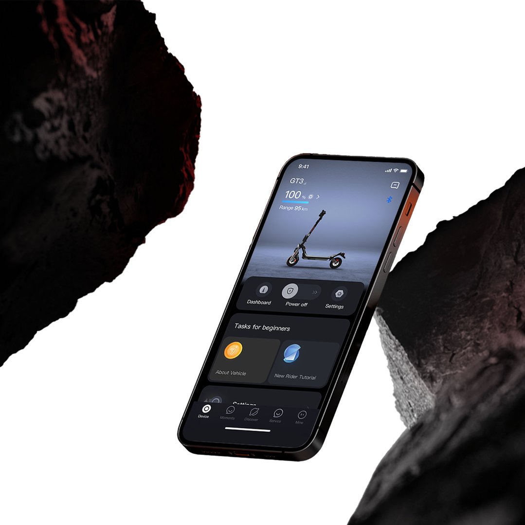 Smartphone displaying electric scooter app interface, surrounded by dark rock formations