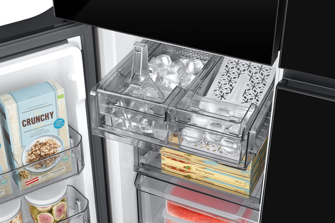 Inside a refrigerator showing ice cubes, frozen pizzas, and cereal boxes