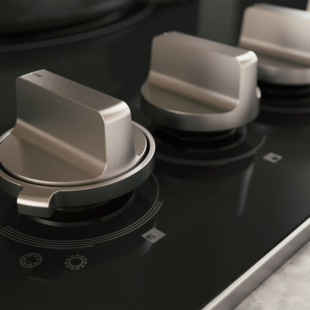 Close up of the control knobs on a black glass cooktop