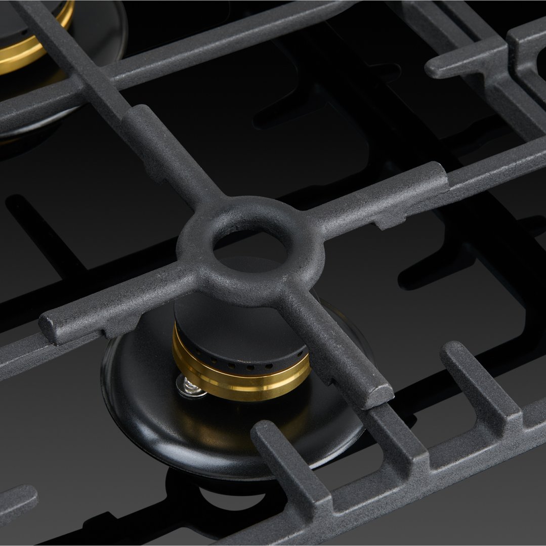 Close up of a black gas on glass cooktop with cast iron trivets