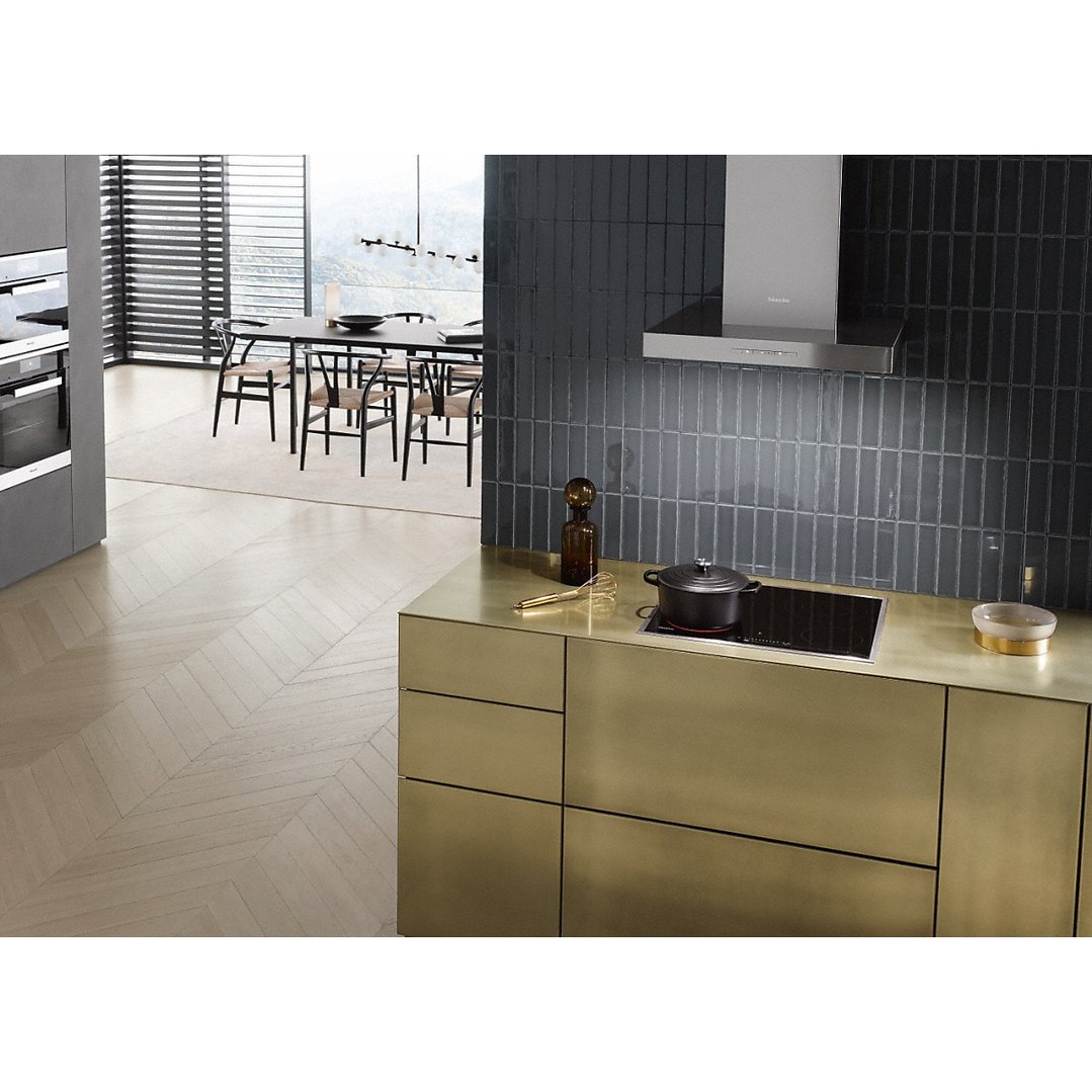 Cooktop with a pot on a gold countertop in a modern kitchen setting