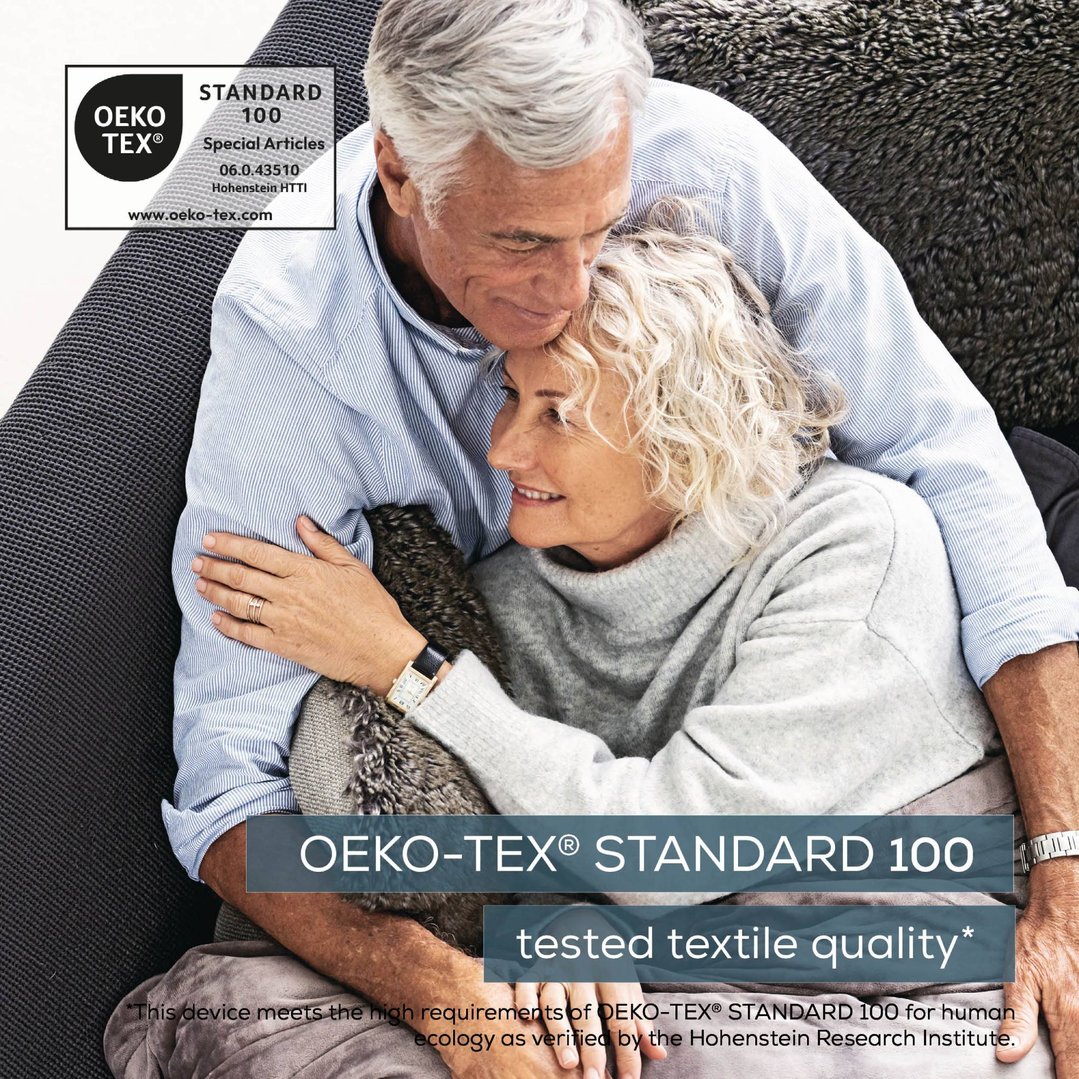 Older couple embracing, woman wearing a heating pad under her sweater