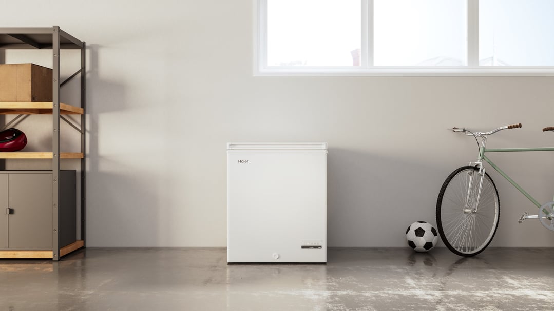 Haier chest freezer in a garage with shelving, a bicycle, and a soccer ball