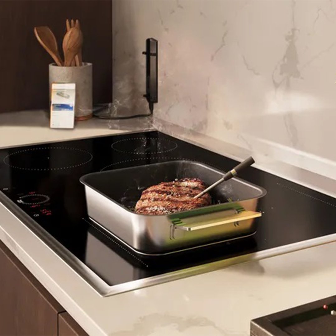 Wireless Meat Probe inserted into a steak cooking on an induction cooktop