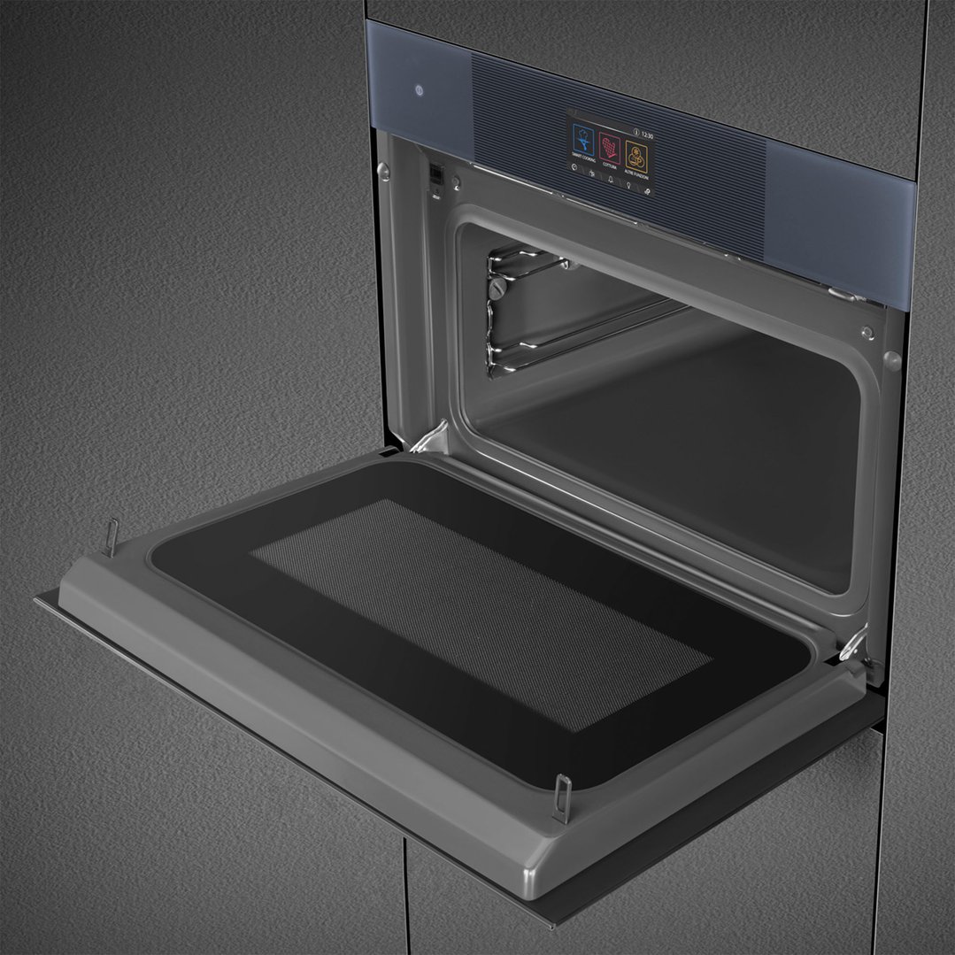 Open compact omnichef oven with digital display built into a dark grey kitchen