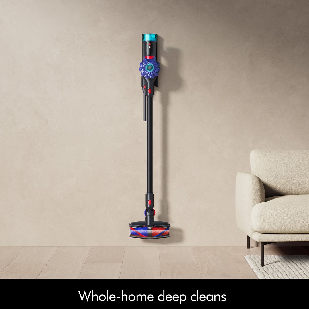Cordless vacuum cleaner mounted on a wall in a living room setting