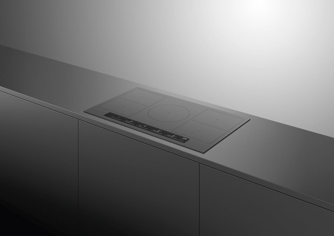 A grey induction cooktop built into a dark grey kitchen countertop