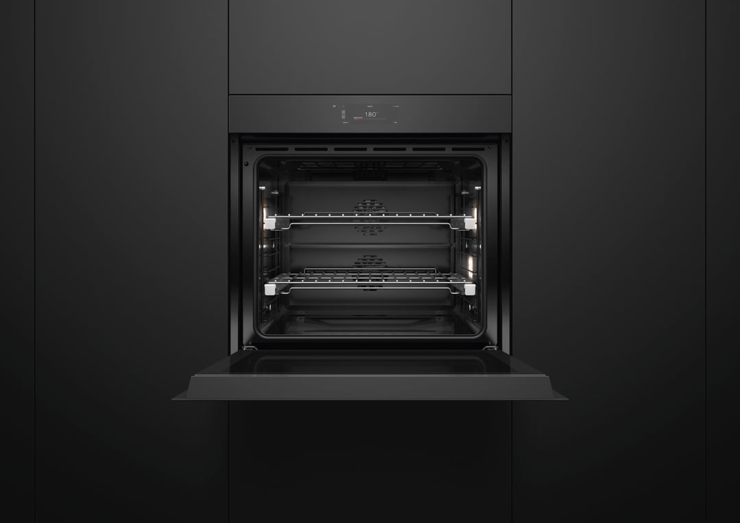 Black built-in oven with door open, showing interior racks and lights
