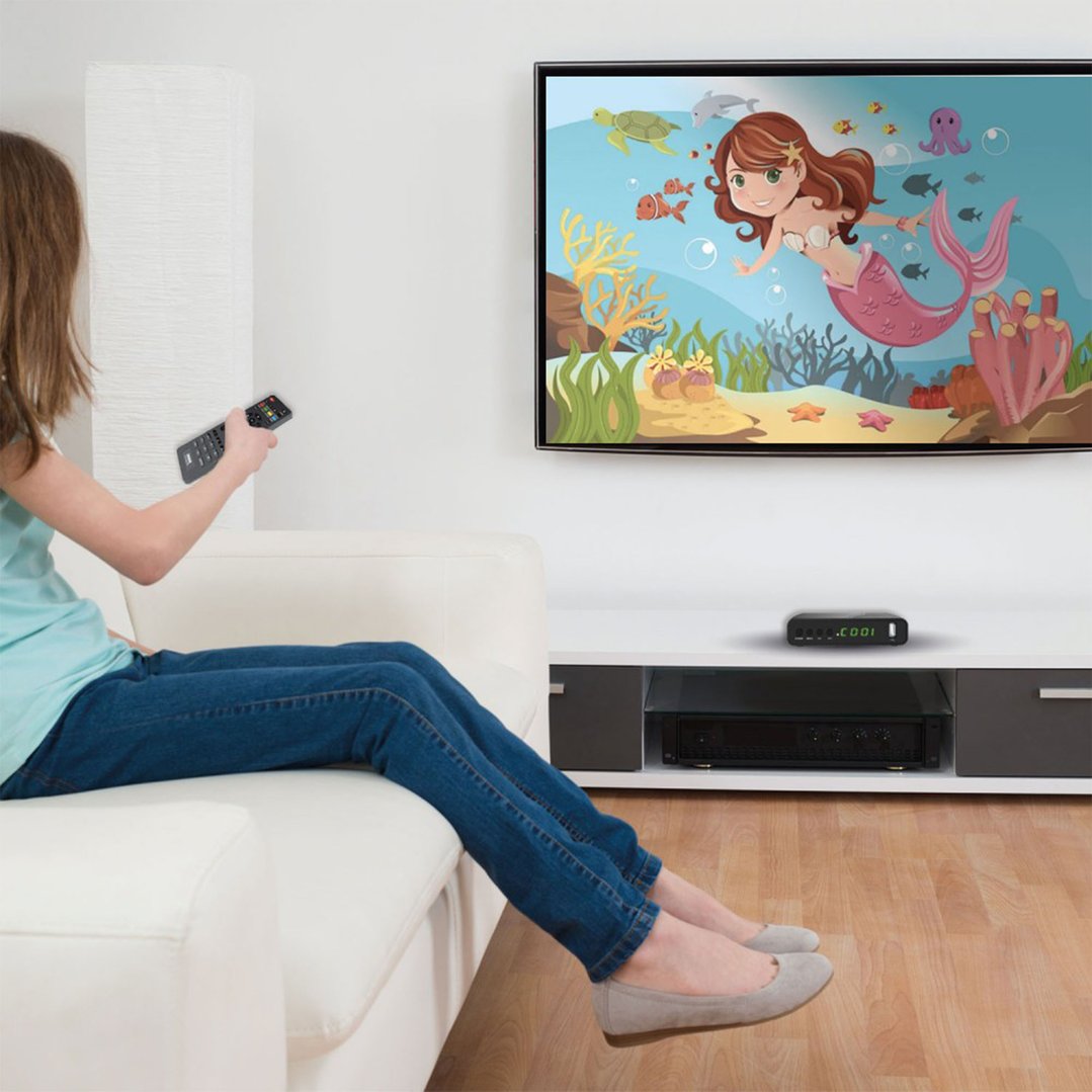 Person on a couch watching a mermaid cartoon on a TV with a set top box