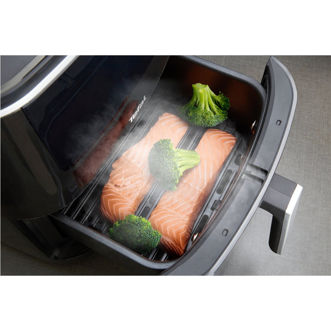Two salmon fillets and broccoli cooking in an open air fryer