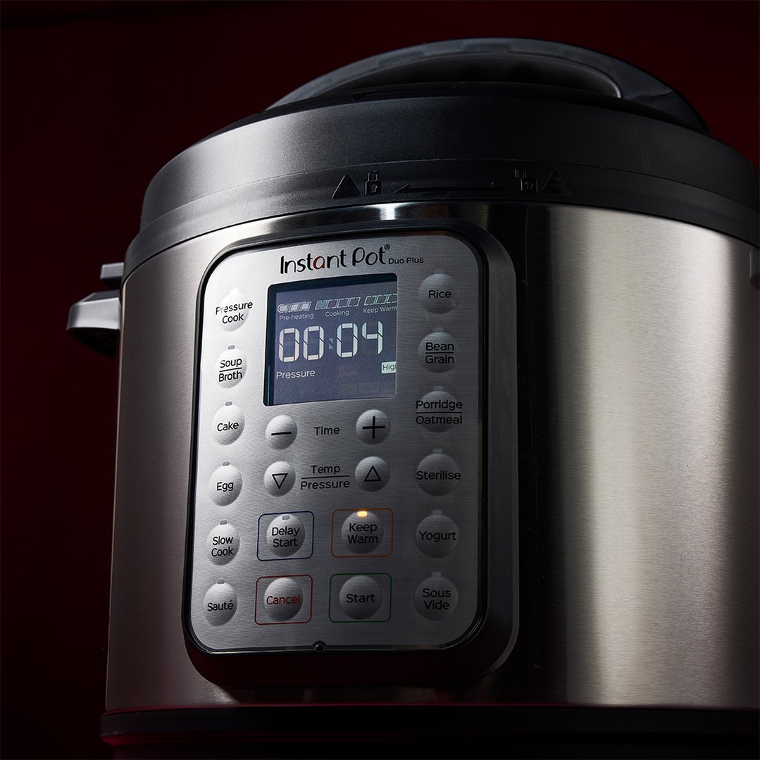 Close up of a multi-pressure slow cooker with its digital display illuminated