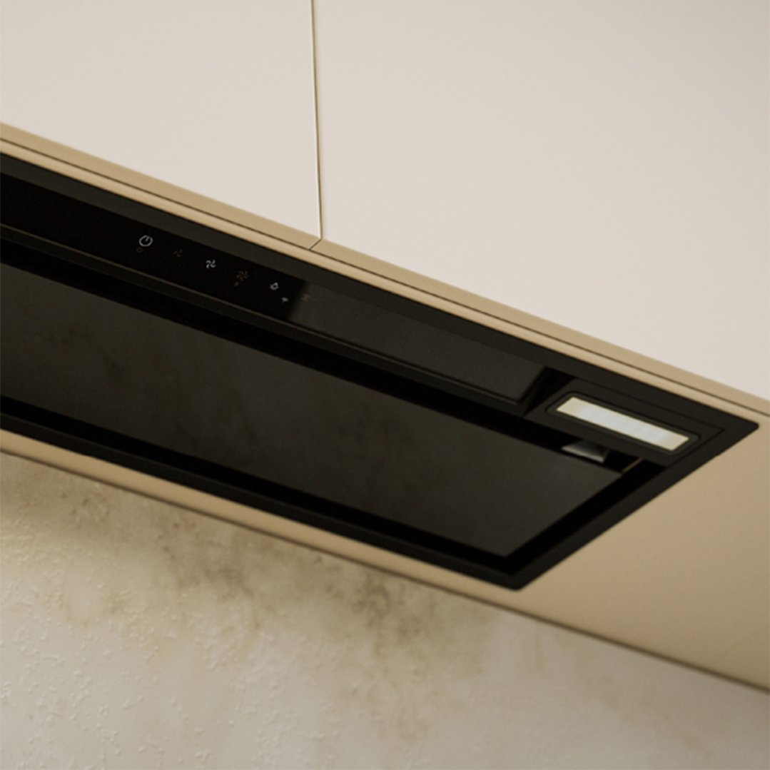 Close up of a black integrated rangehood with controls and light