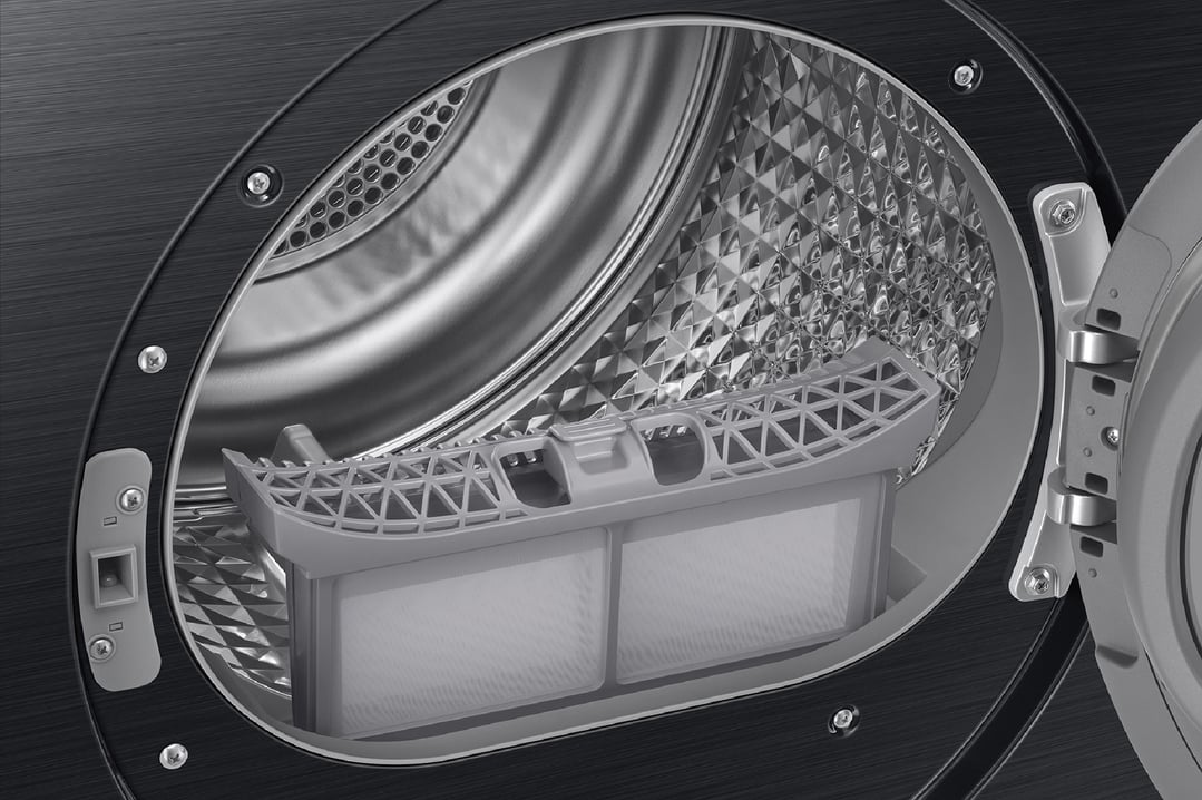 Close-up of the open drum and lint filter inside a black heat pump dryer