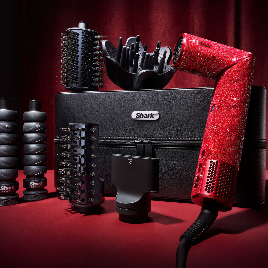 Red ruby diamond hair styler with attachments and case on a red surface