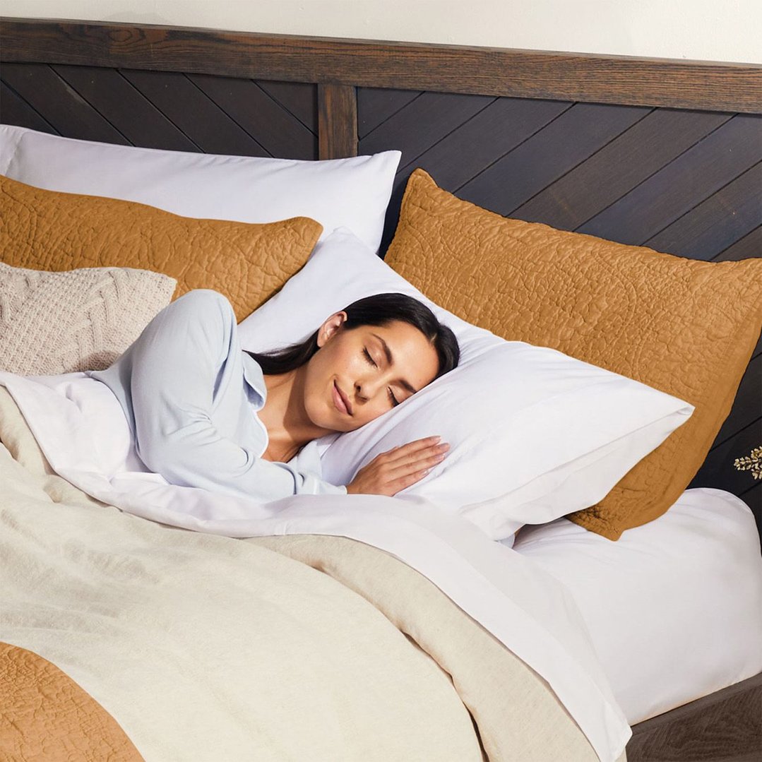 Woman sleeping soundly in bed with an electric blanket and pillows