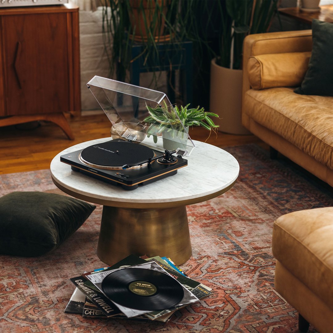 Black and bronze turntable on a marble coffee table in a living room