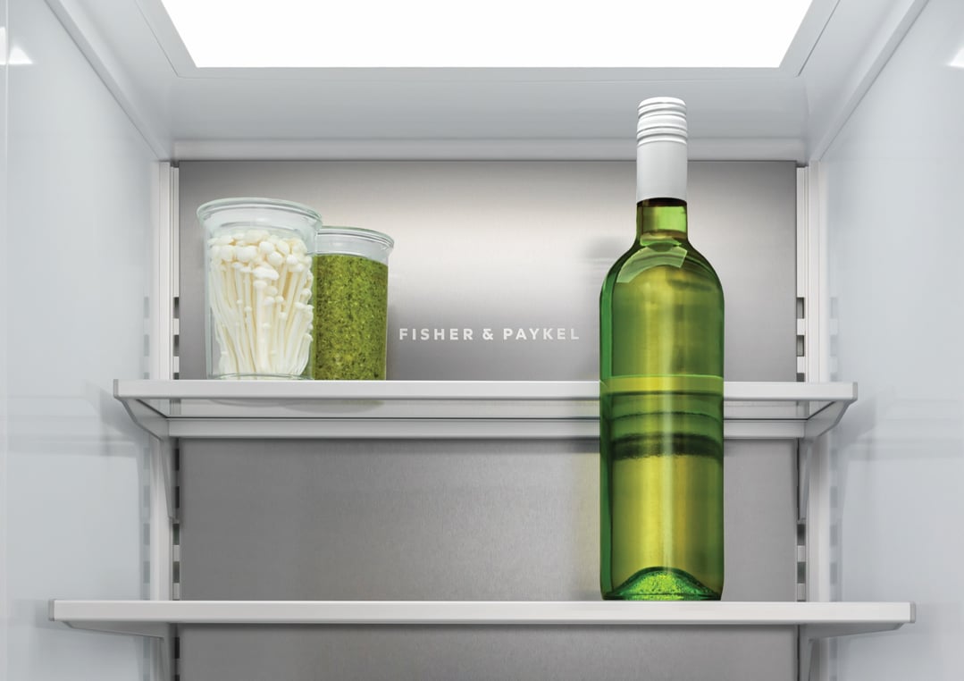 Interior view of a Fisher & Paykel integrated dual zone refrigerator with items on shelves
