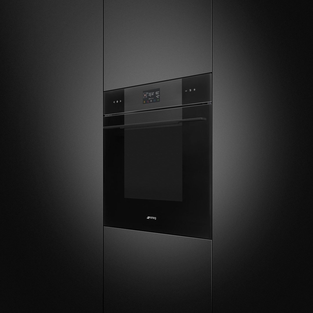 A black built-in oven with a digital display in a dark kitchen cabinet