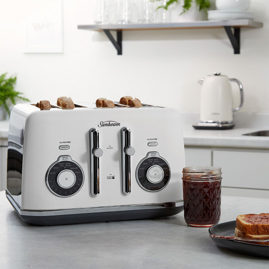 White 4-slice toaster on a kitchen counter with toast and jam