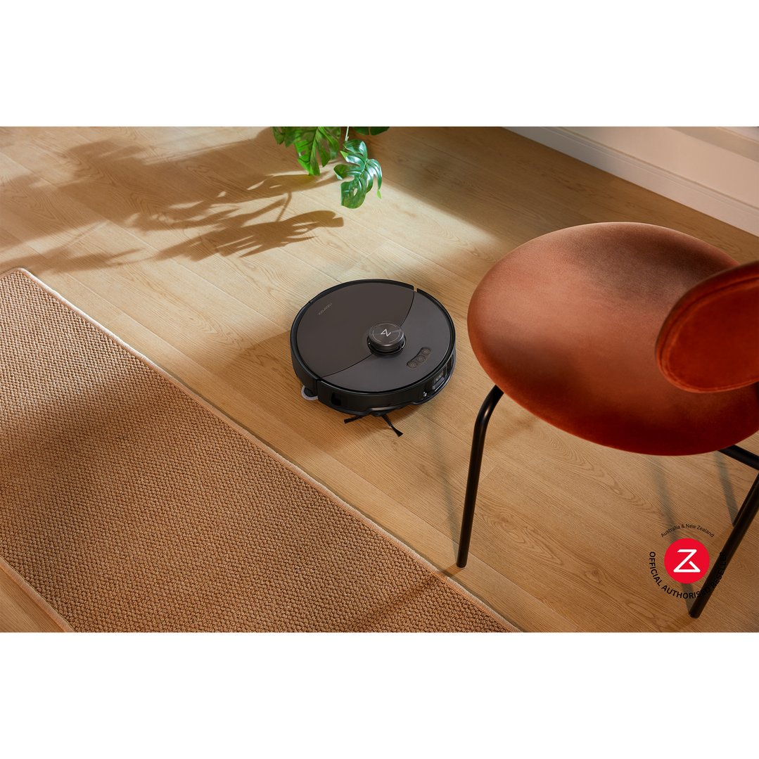 Roborock S8 MaxV Ultra robotic vacuum on a wooden floor next to a chair