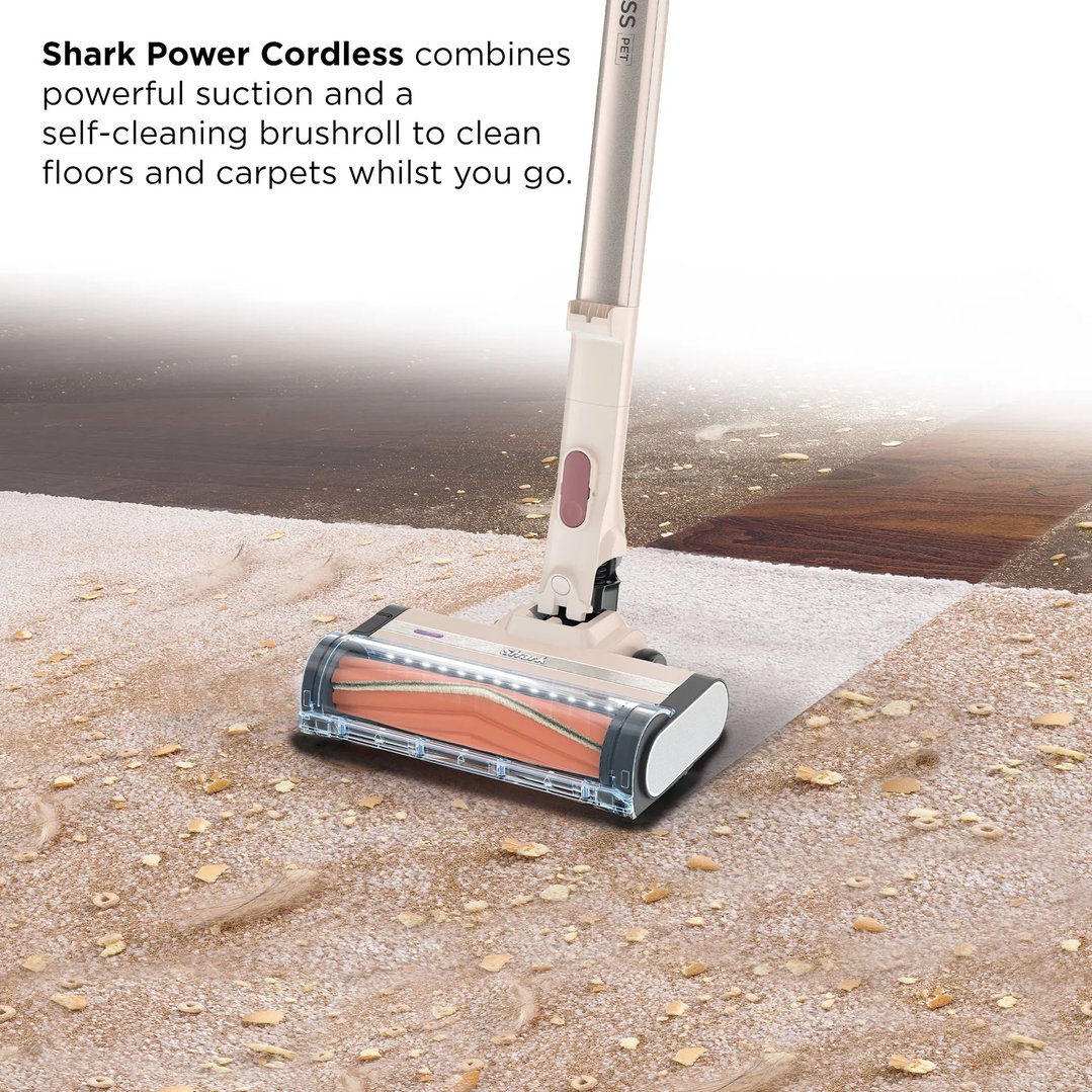 Shark Power Cordless handstick vacuum cleaning a carpet with debris and crumbs