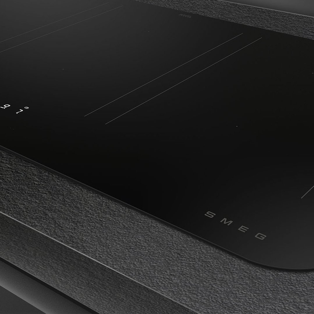 Close up of a black induction cooktop with controls and SMEG logo
