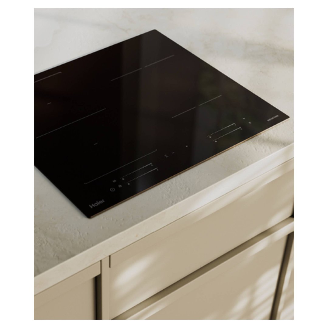 Black induction cooktop built into a light-colored kitchen countertop