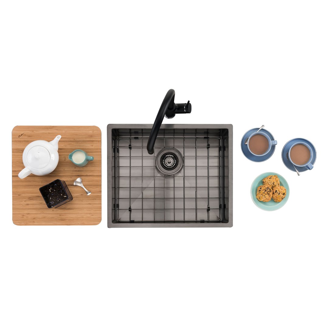 Gunmetal sink with a black faucet, surrounded by tea set and cookies