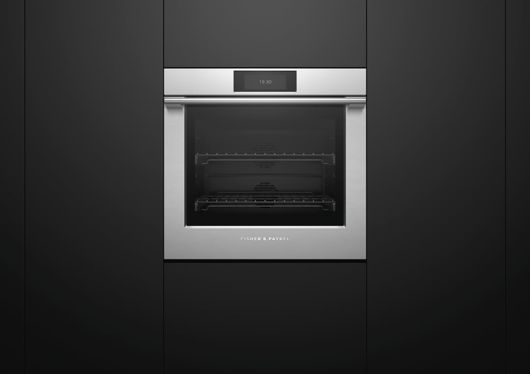 Built-in stainless steel oven with a digital display showing 19:30 in a dark kitchen