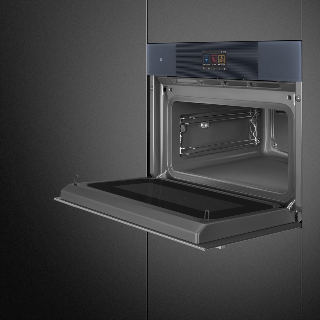 Built-in compact omnichef oven with the door open, showing the interior