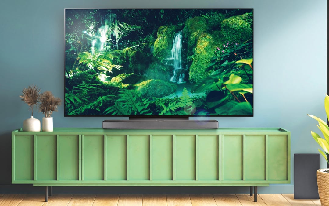 Sound bar and TV on a green cabinet in a living room