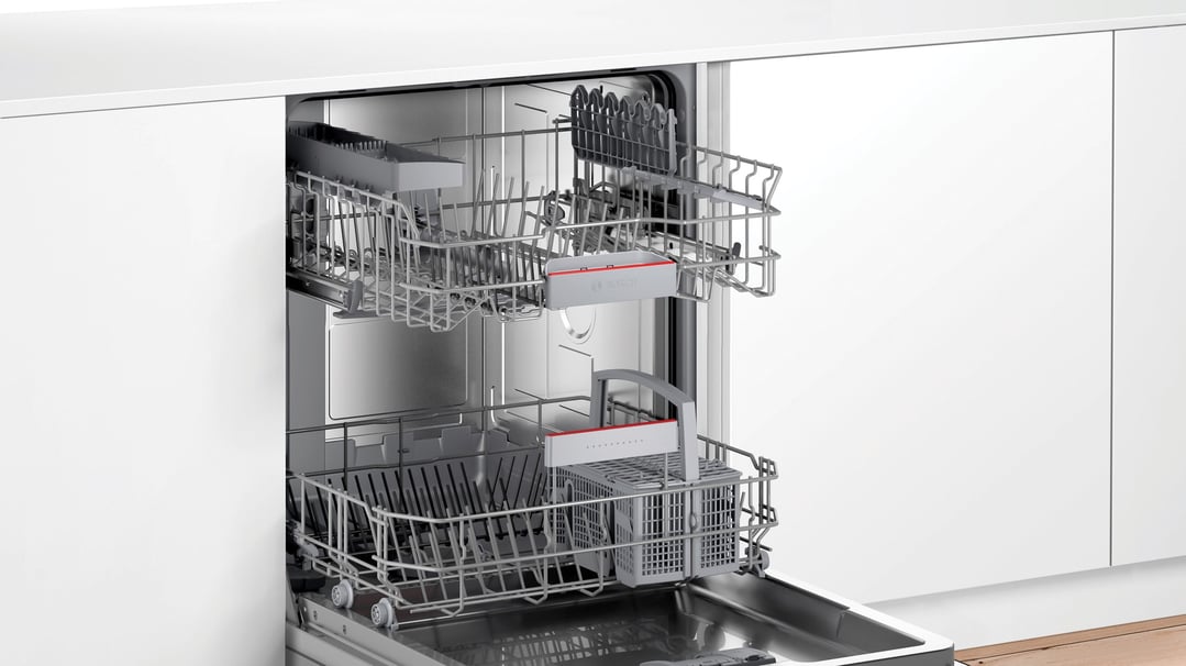 Open built-under dishwasher with racks extended in a modern kitchen setting