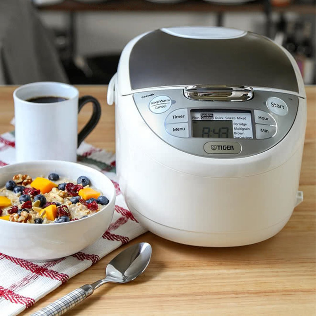 White TIGER multi-functional rice cooker on a wooden table with breakfast items