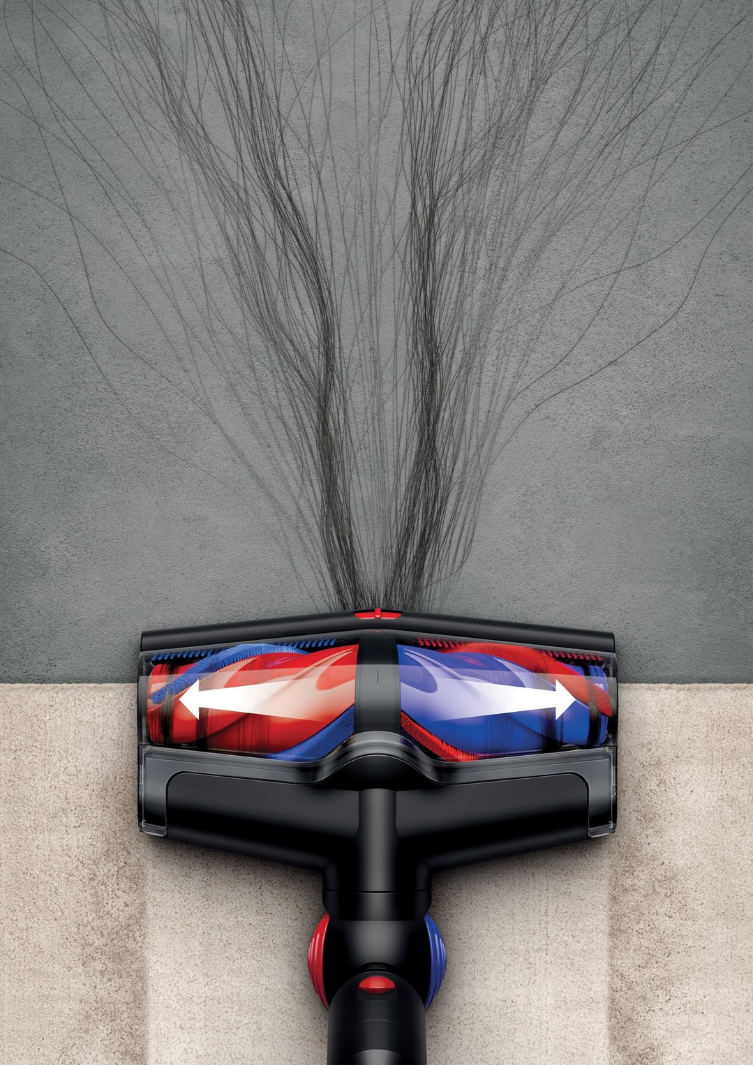Dyson handStickVacuum cleaning hair from a grey carpet, showing brush head
