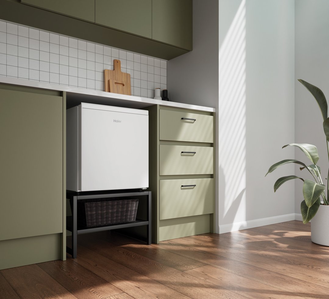 Haier bar refrigerator in a green kitchen with wooden floors and a plant