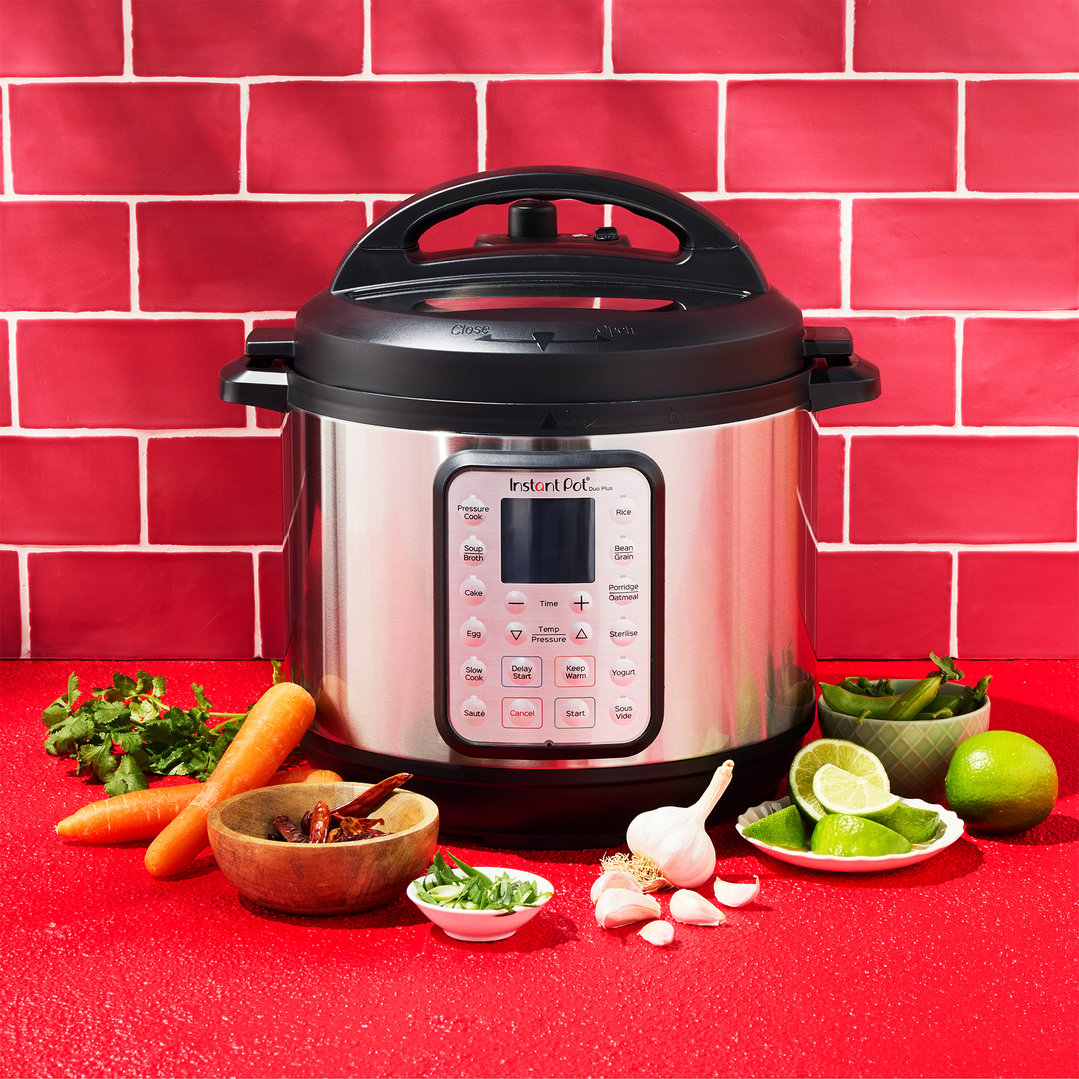 Instant Pot Duo Plus multi-pressure slow cooker with ingredients on a red counter