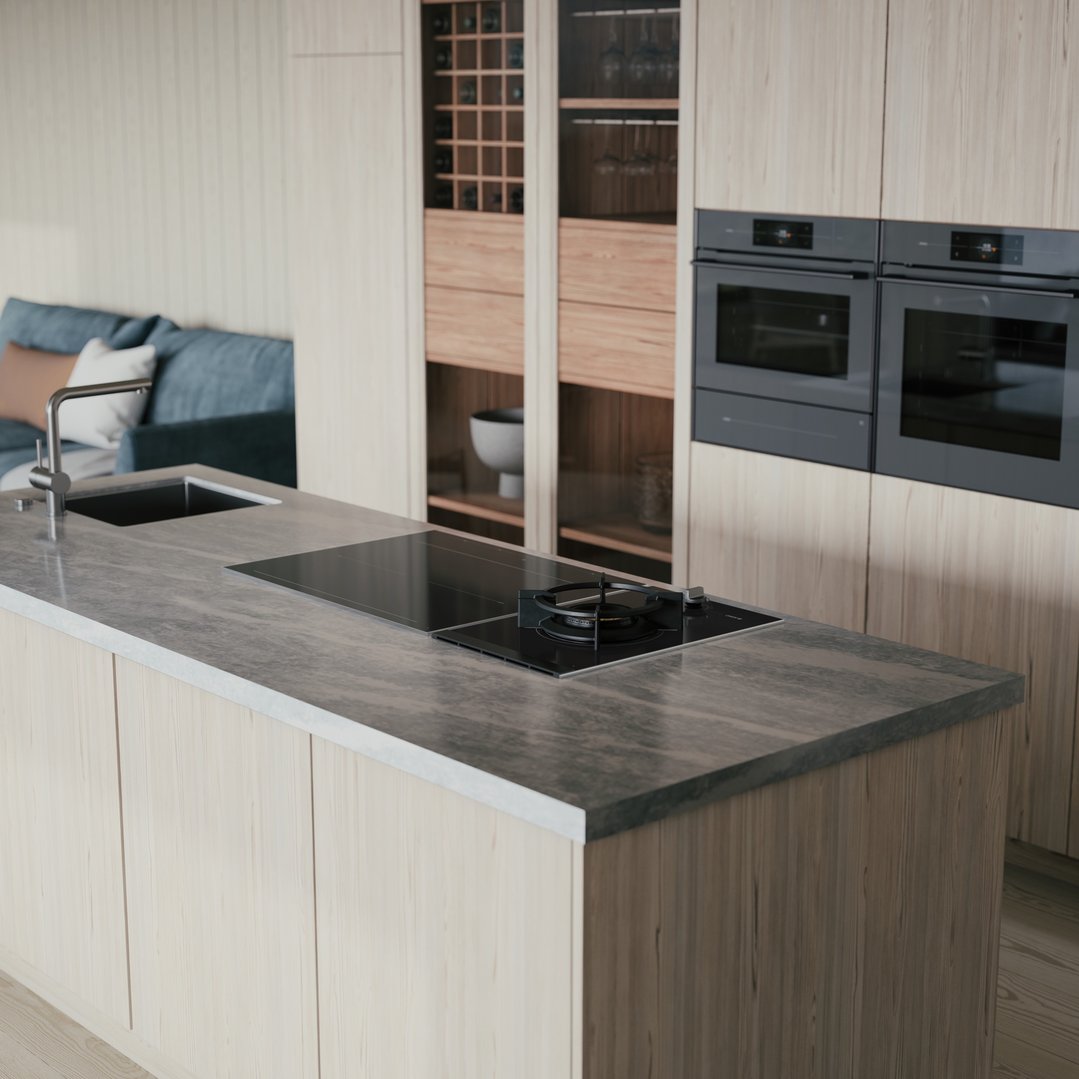 Kitchen island with a cooktop and sink, with built-in ovens in the background