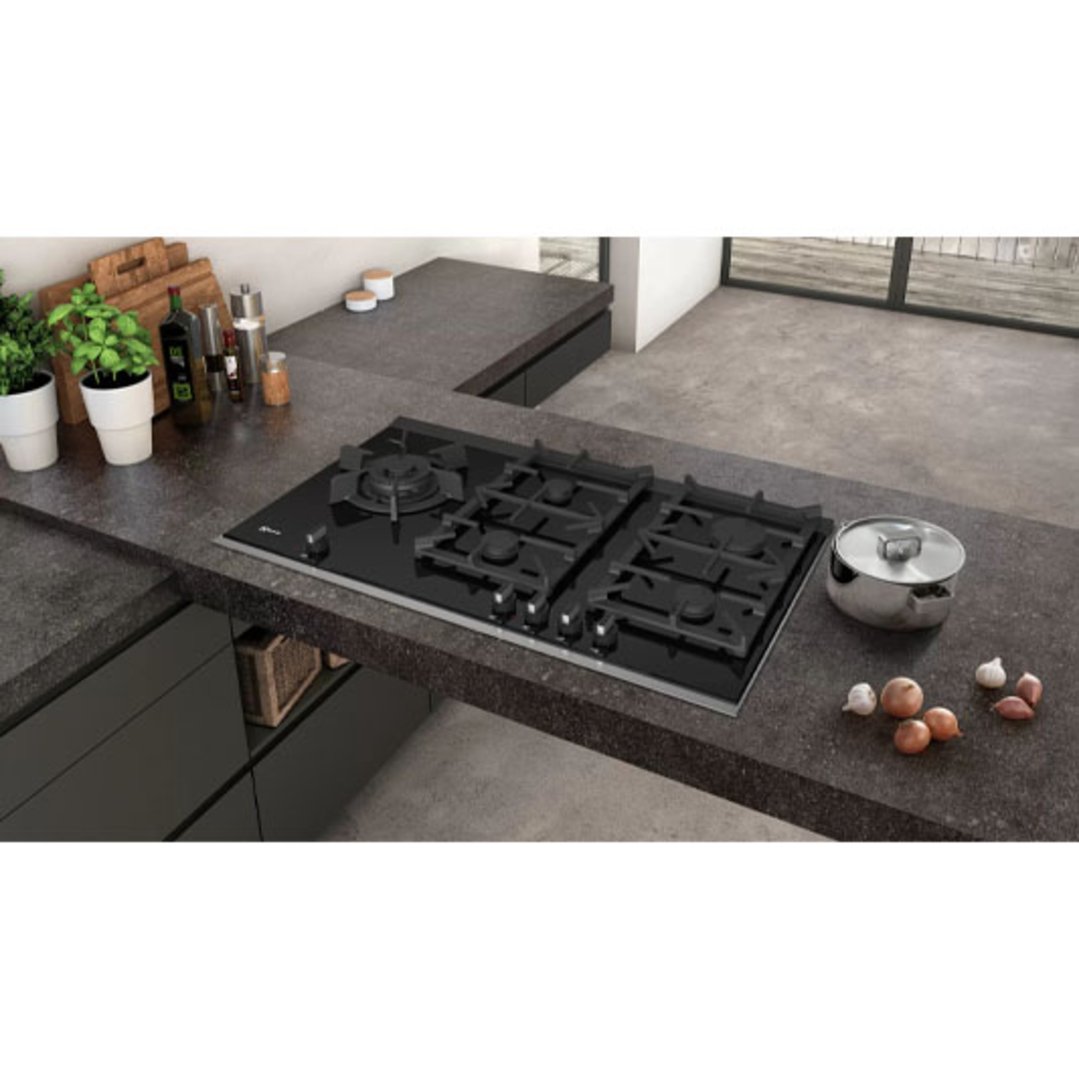 Black gas cooktop integrated into a dark countertop in a modern kitchen