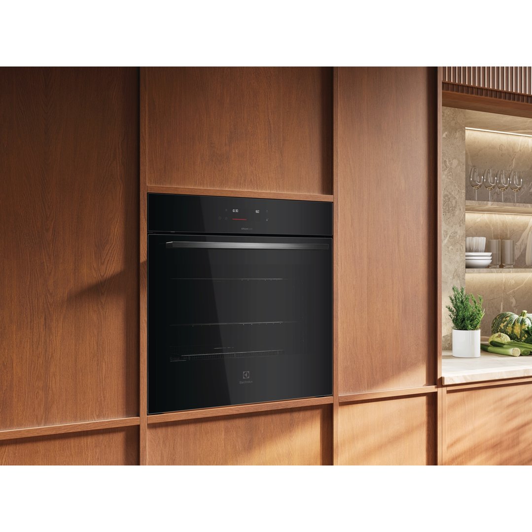 Built-in black oven with SteamBake in a modern kitchen with wooden cabinetry