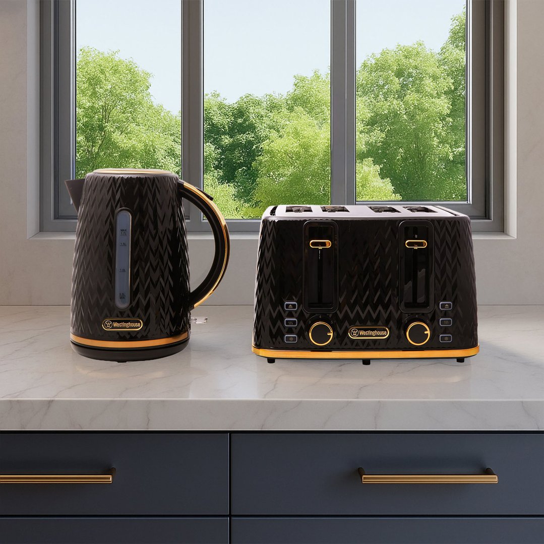 Black and gold kettle and toaster on a kitchen counter with a window view