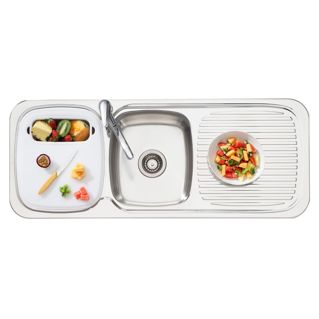 Overhead view of a stainless steel sink with fruit being prepared