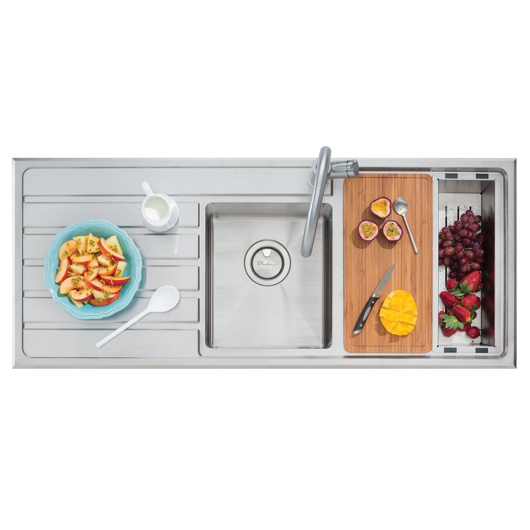 Overhead view of a stainless steel sink with fruit and milk on the drainer