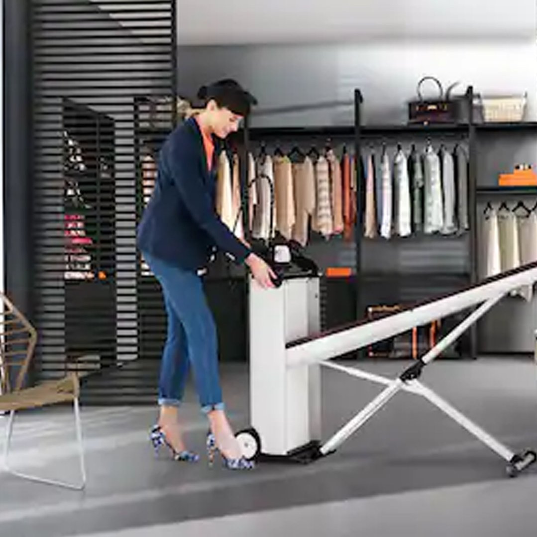 Woman using a Fashion Master Steam Ironing System in a walk-in wardrobe