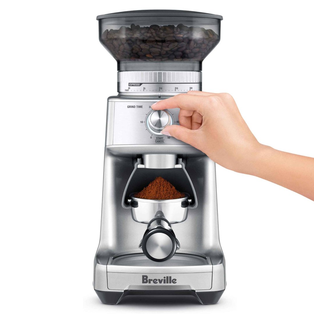Hand adjusting grind time on a Breville coffee grinder with ground coffee
