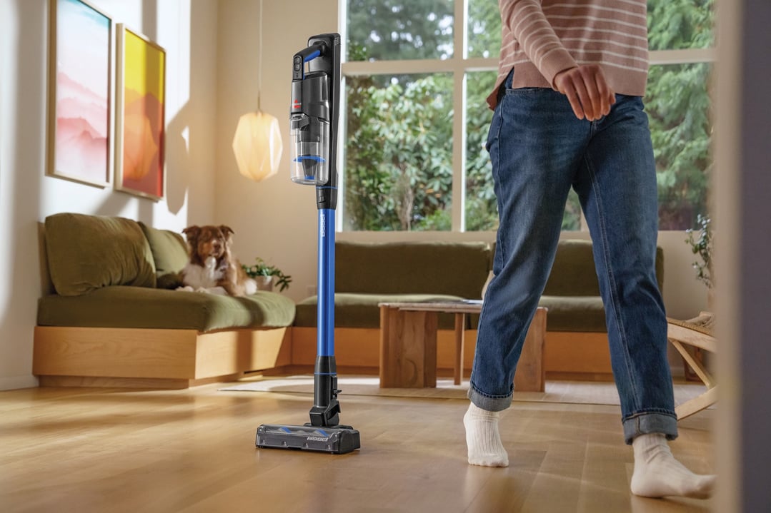 BISSELL handStickVacuum standing on a wooden floor in a living room