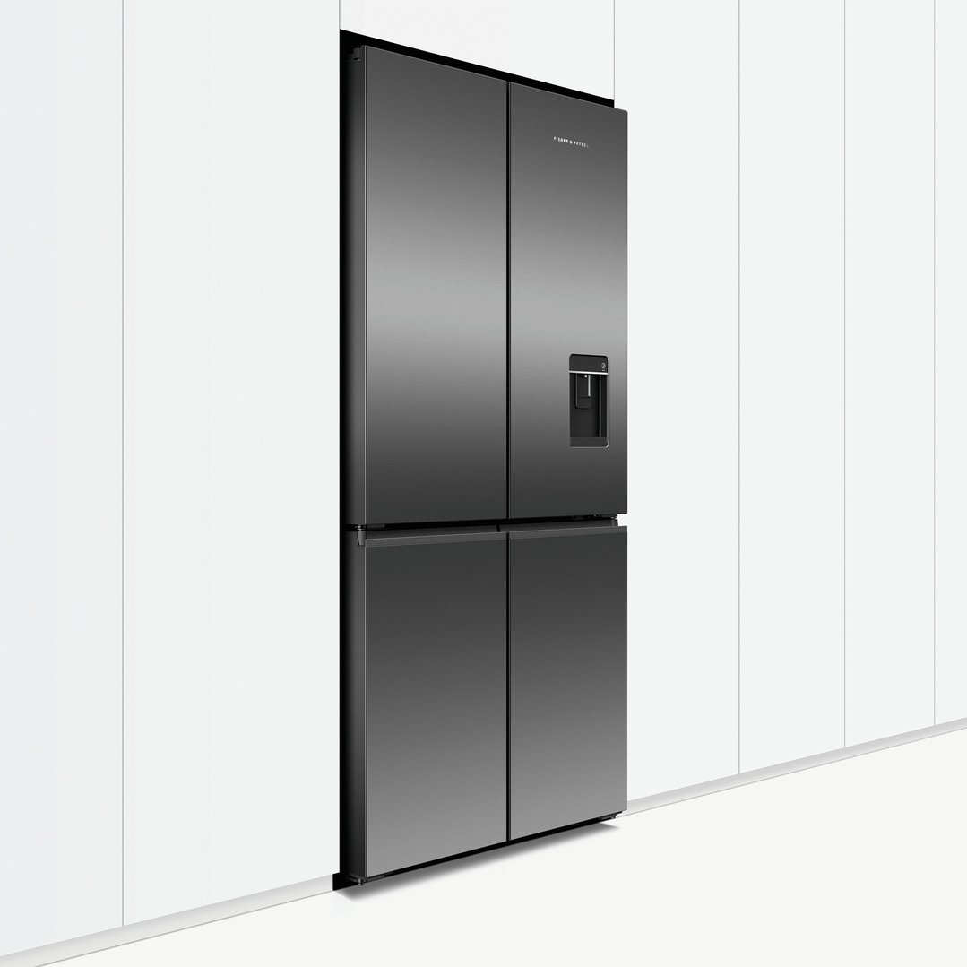 Dark stainless steel quad door refrigerator freezer built into a white kitchen