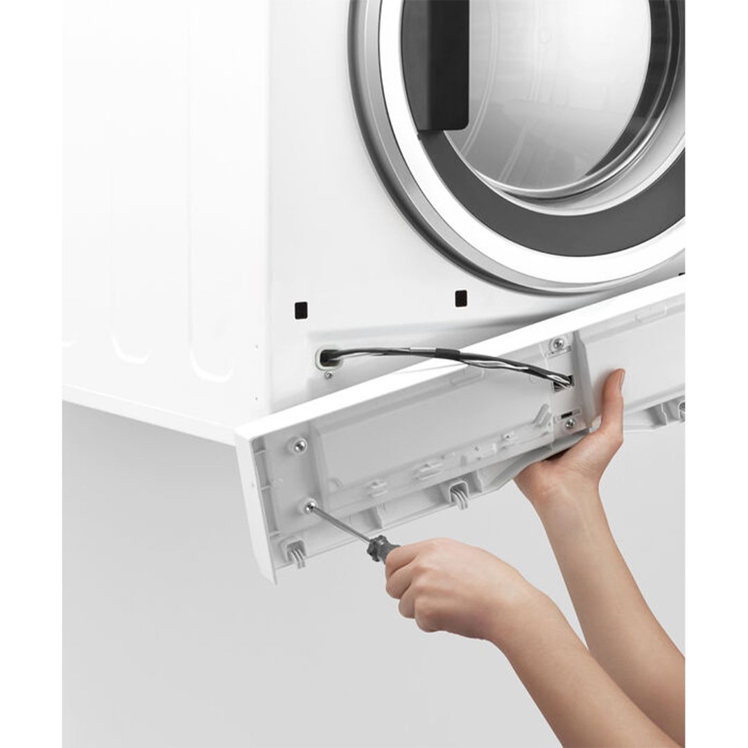 Hands using a screwdriver to install a panel on a white vented dryer