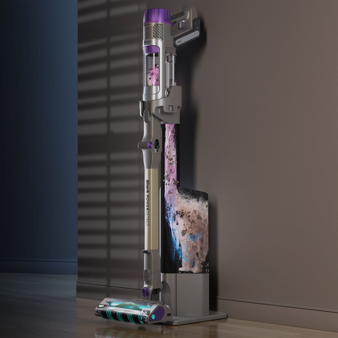 Cordless handstick vacuum on its charging stand, showing dust collection in a room