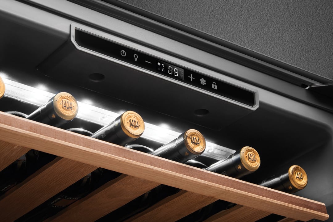 Close-up of a built-in wine cooler with bottles on wooden racks